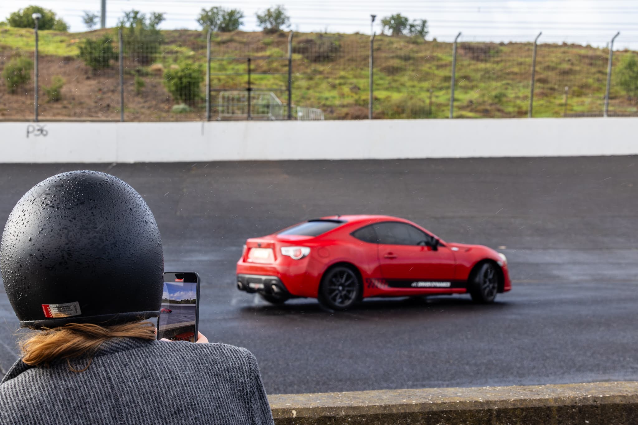 customer taking a photo of the red 86 drifting at calder park raceway